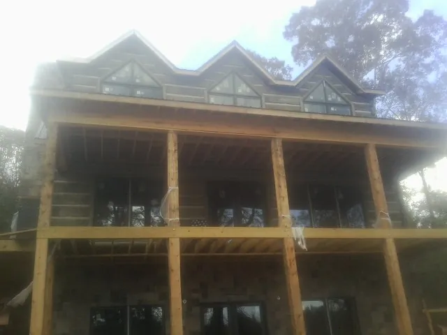 Dormers and porch framing on a large log home under construction — Roof Coating work by our crew in Leechburg
