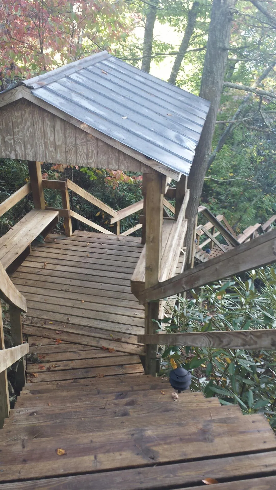 Metal roofed shelter over wooden steps on a wooded walkway — Skylight Repair & Installation work by our crew in Leechburg