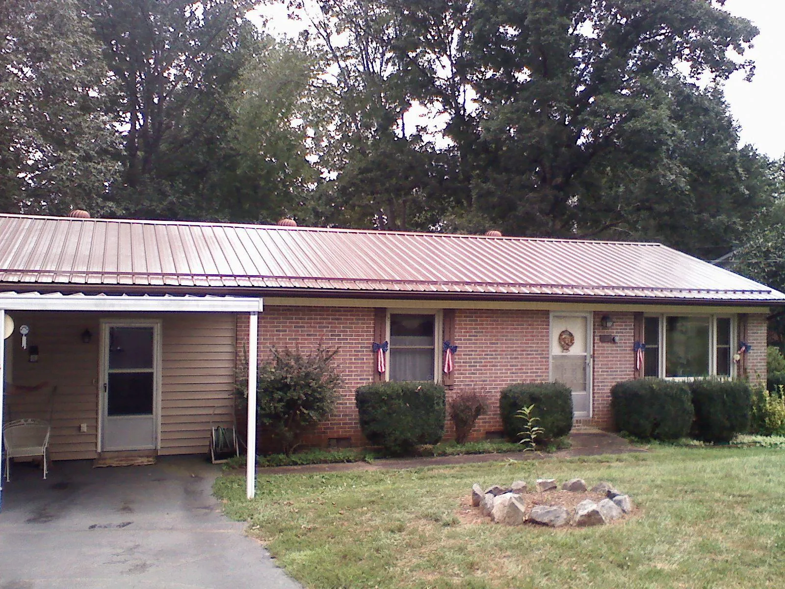 Bronze metal roof and carport on a brick ranch home — Roof Repair work by our crew in Leechburg
